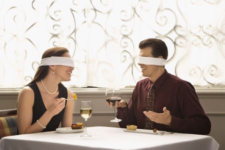 2190840 - mid adult caucasian couple dining in a restaurant with blindfolds over eyes.