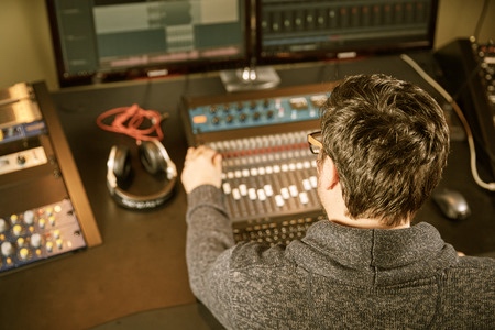 51732915 - sound engineer is working on a mixing console in a sound studio