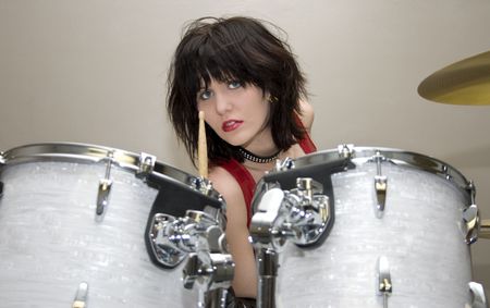 3740974 - beautiful teen girl in red vinyl dress and dog collar sitting at drum set.